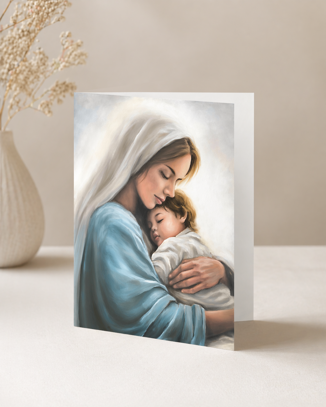 Card with an illustration of mother Mary holding child Jesus. Card on a white surface.