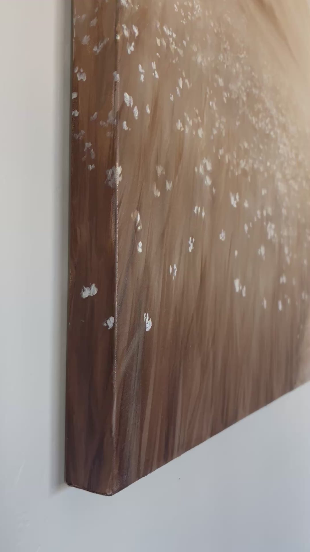 A close up video of the Oil painting of Christ walking with a lamb on a winding path. Painting is on a large canvas hung on a wall. Monochromatic painting, tans and browns.